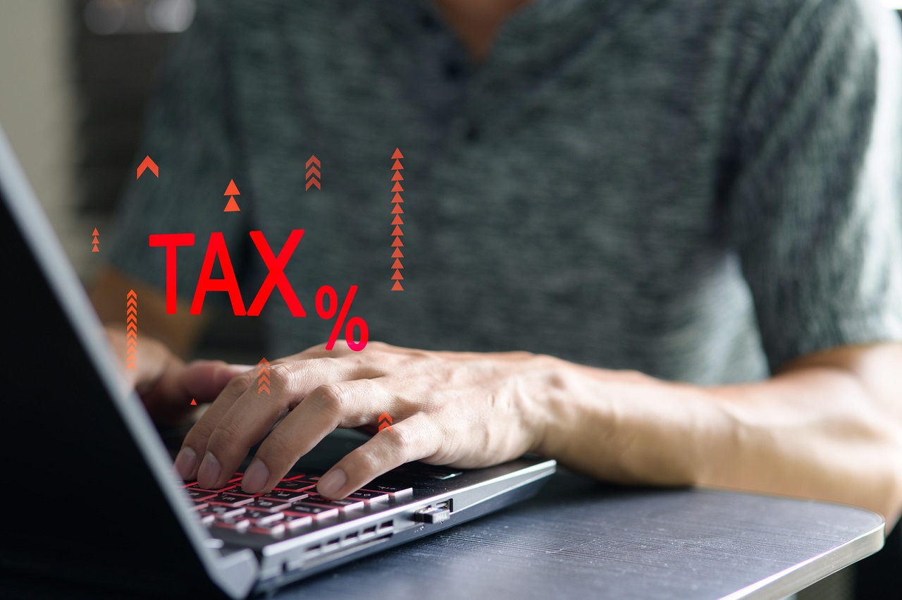 A business professional types on a laptop with a focus on financial aspects like export tax increases. Ideal for discussions on revenue strategy and planning.